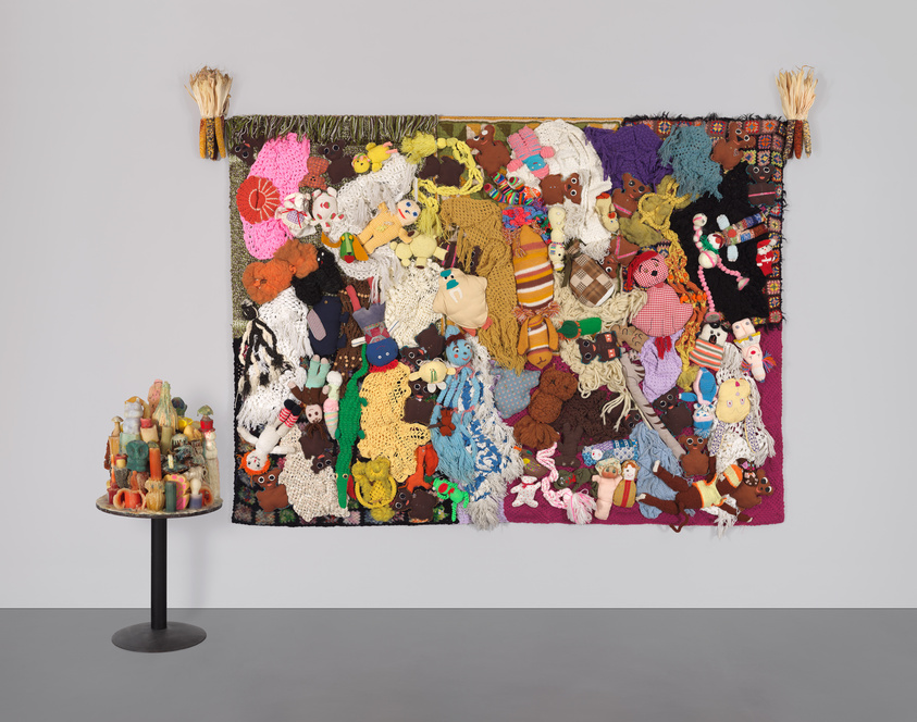 Eine horizontale Leinwand, bedeckt mit Stofftieren und afghanischen Decken in gedämpften Farben.